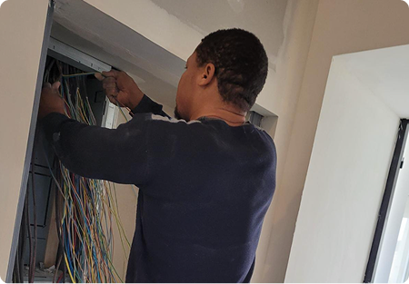 Technicien H Tension Électricité effectuant le câblage d’un tableau électrique à Issy-les-Moulineaux