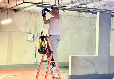 Électricien H Tension Électricité installant un éclairage dans un local technique à Issy-les-Moulineaux